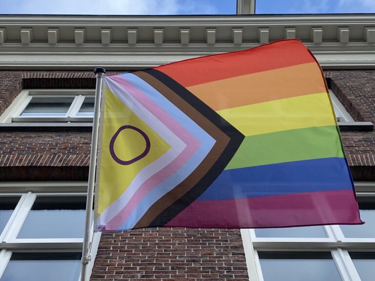 Regenboogvlag Progress Pride incl Intersex aan de gevel van het COC